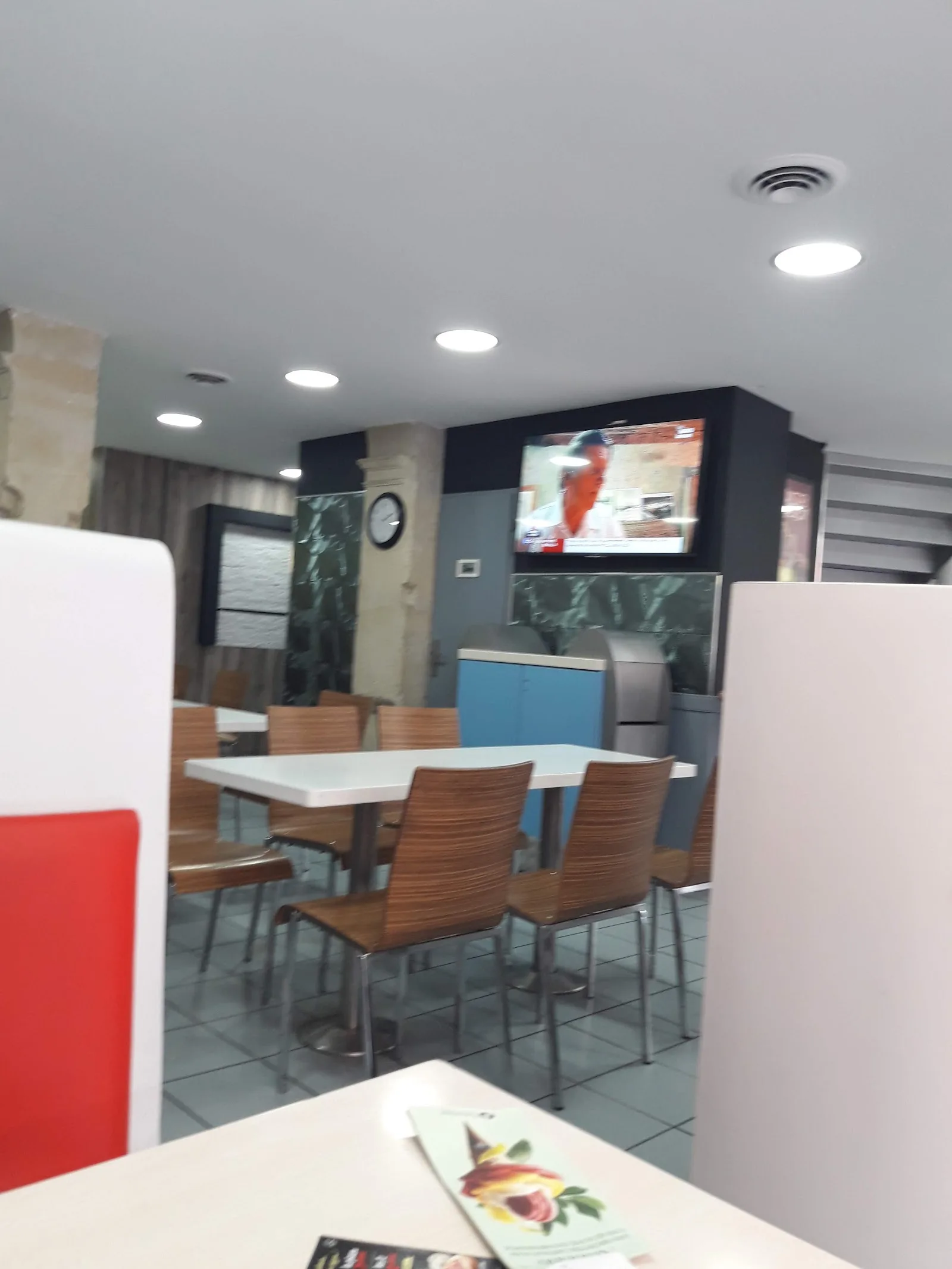 La salle de Buns Burger : tables, chaises et écran